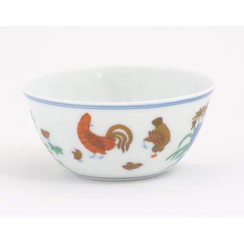 49 - A Chinese famille rose tea bowl decorated with cockerel / rooster, hen / chicken and chicks, flowers... 