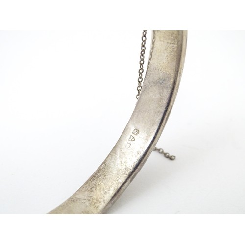 727 - A silver bracelet of bangle form with engraved acanthus scroll decoration, hallmarked Chester 1952. ... 