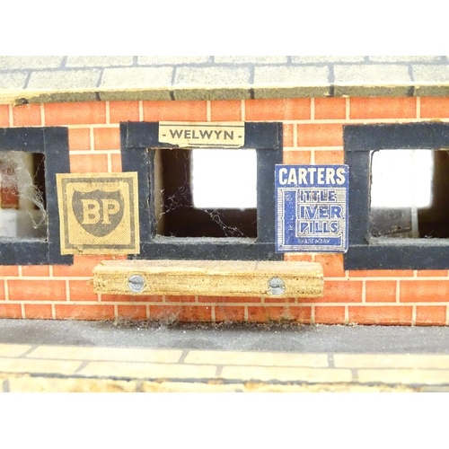 1468 - Toys: A 20thC scratch built wooden model railway station / platform with various adverts for Shell, ... 