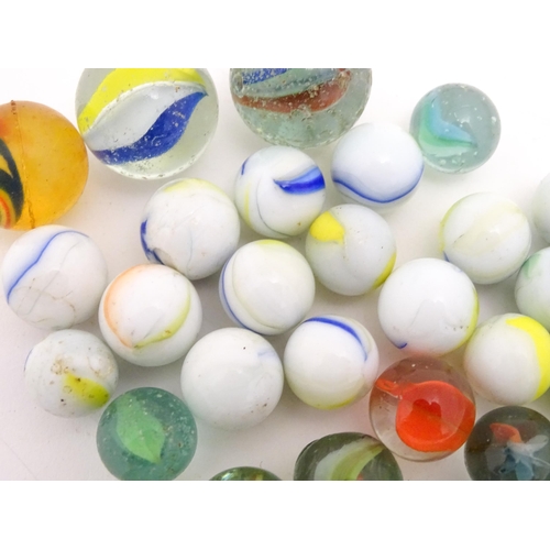 1469 - A quantity of assorted glass marbles, many with colours twists. Largest approx. 1