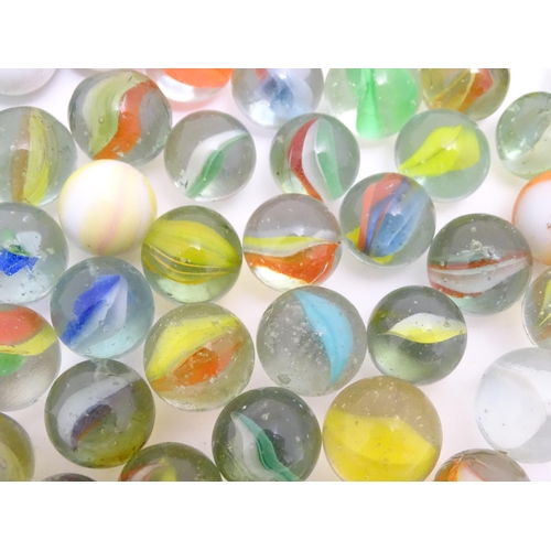 1469 - A quantity of assorted glass marbles, many with colours twists. Largest approx. 1