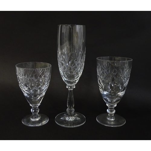 303 - A large quantity of cut glass / crystal glassware to include champagne flutes,  assorted drinking gl... 