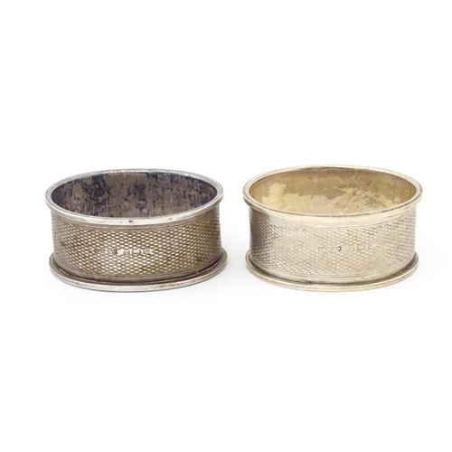 489 - A pair of napkin rings of oval form with engine turned decoration. Hallmarked Birmingham 1952 maker ... 