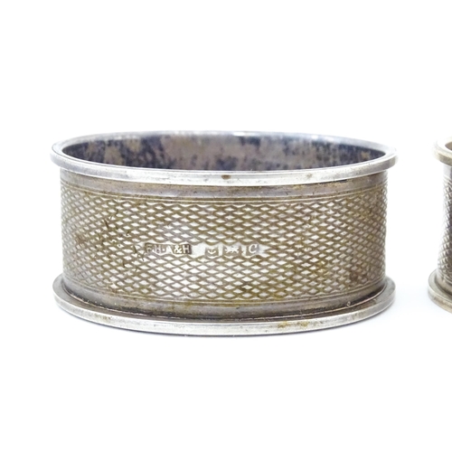 489 - A pair of napkin rings of oval form with engine turned decoration. Hallmarked Birmingham 1952 maker ... 