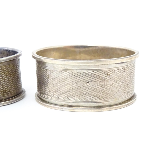 489 - A pair of napkin rings of oval form with engine turned decoration. Hallmarked Birmingham 1952 maker ... 