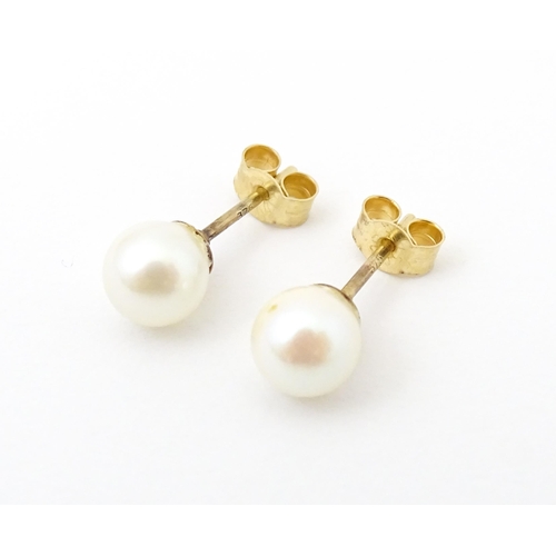 740 - A pair of 9ct gold stud earrings set with pearls. Approx 1/4