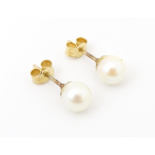 740 - A pair of 9ct gold stud earrings set with pearls. Approx 1/4