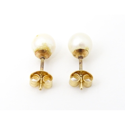 740 - A pair of 9ct gold stud earrings set with pearls. Approx 1/4