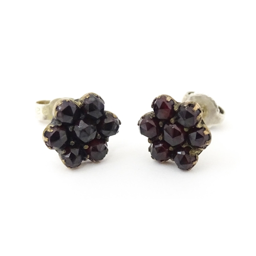 741 - A pair of silver stud earrings decorated with garnets set in gilt metal.  Approx 1/2