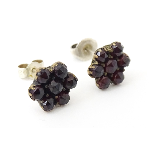 741 - A pair of silver stud earrings decorated with garnets set in gilt metal.  Approx 1/2