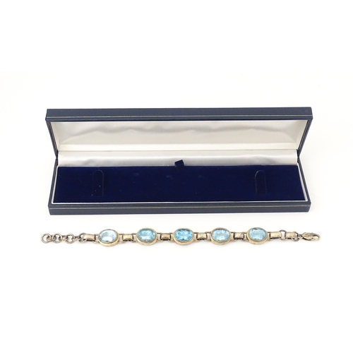 757 - A silver bracelet set with 5 oval cut topaz.