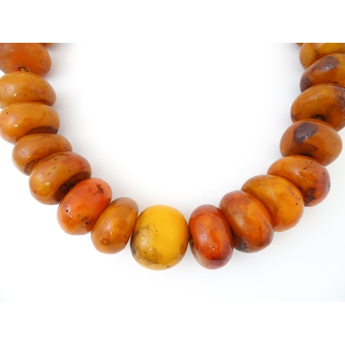 794 - A necklace of large amber coloured beads. Approx 22