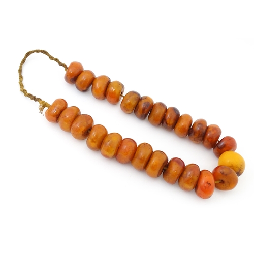 794 - A necklace of large amber coloured beads. Approx 22