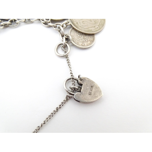 800 - A silver and white metal bracelet set with various coin formed pendant charms and a gilt metal penda... 