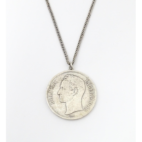 803 - A white metal longuard / watch chain with pendant formed from a silver Venezuelan coin dated 1921 an... 