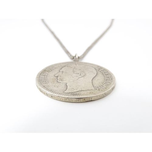 803 - A white metal longuard / watch chain with pendant formed from a silver Venezuelan coin dated 1921 an... 