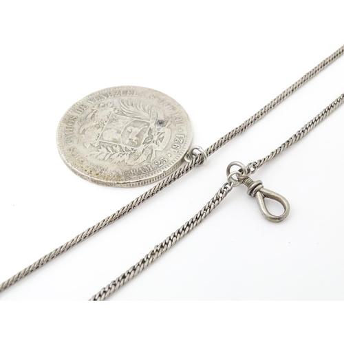 803 - A white metal longuard / watch chain with pendant formed from a silver Venezuelan coin dated 1921 an... 