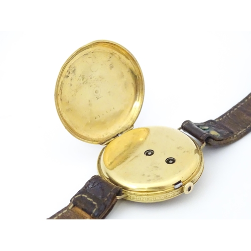 814 - An 18ct gold pocket watch converted into a wristwatch, with engraved floral and scroll detail. The d... 