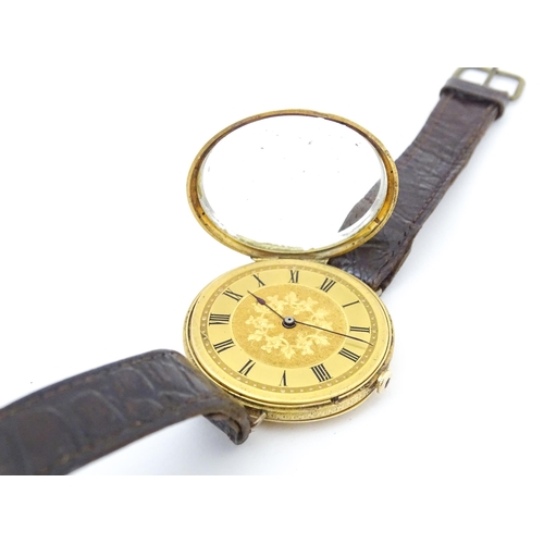 814 - An 18ct gold pocket watch converted into a wristwatch, with engraved floral and scroll detail. The d... 