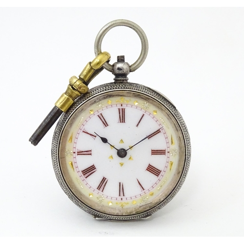 839 - A Continental .935 silver fob watch with engraved decoration and white enamel dial with gilt highlig... 