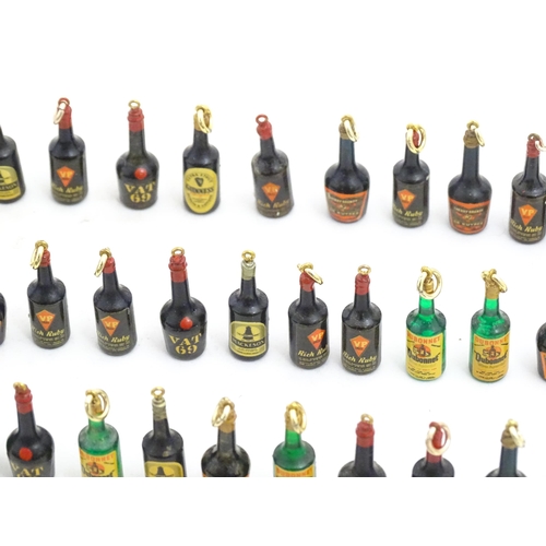 1200 - A quantity of 20thC pendant charms / fobs modelled as miniature bottles of alcohol, to include Guinn... 