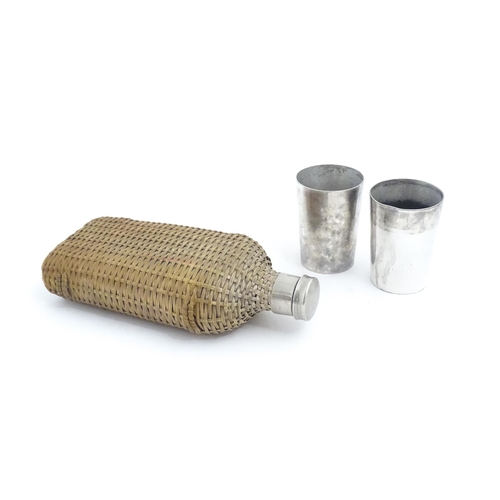 1201 - A 20thC wicker covered glass bottle. Together with two silver plate beakers by Mappin & Webb. Bottle... 