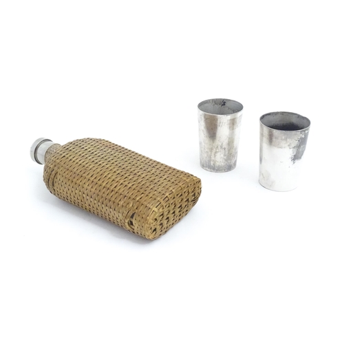 1201 - A 20thC wicker covered glass bottle. Together with two silver plate beakers by Mappin & Webb. Bottle... 