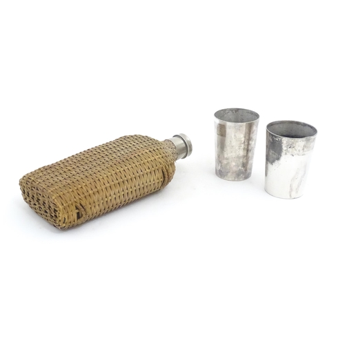 1201 - A 20thC wicker covered glass bottle. Together with two silver plate beakers by Mappin & Webb. Bottle... 