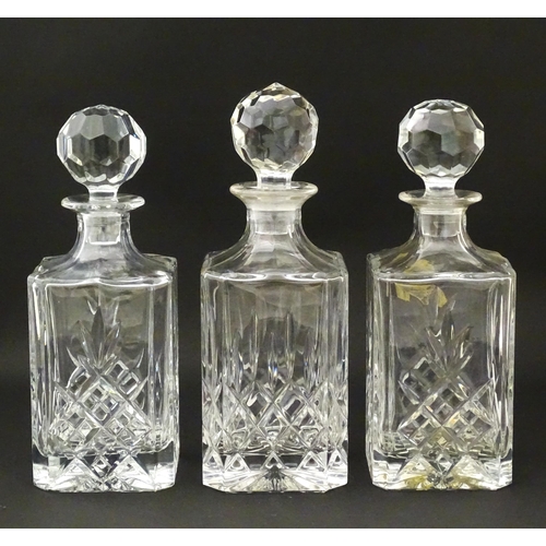 1211 - A 20thC mahogany tantalus with three cut glass decanters. Approx. 13