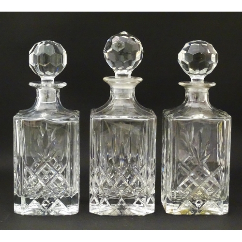 1211 - A 20thC mahogany tantalus with three cut glass decanters. Approx. 13