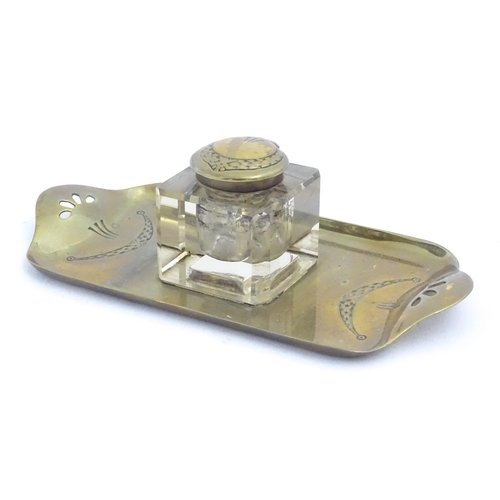 1219 - A 20thC cast brass desk standish, the central glass inkwell flanked by engraved swag decoration and ... 