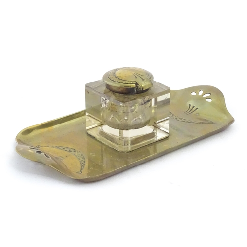 1219 - A 20thC cast brass desk standish, the central glass inkwell flanked by engraved swag decoration and ... 