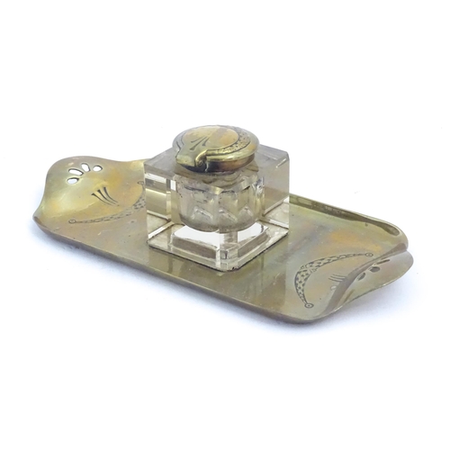 1219 - A 20thC cast brass desk standish, the central glass inkwell flanked by engraved swag decoration and ... 