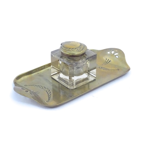 1219 - A 20thC cast brass desk standish, the central glass inkwell flanked by engraved swag decoration and ... 