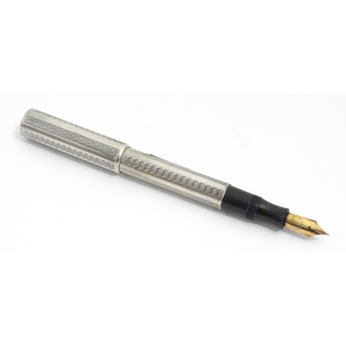 1222 - A mid 20thC white metal fountain pen, the clip indistinctly stamped, fitted with a 14CT gold nib. Ap... 