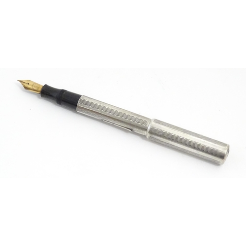 1222 - A mid 20thC white metal fountain pen, the clip indistinctly stamped, fitted with a 14CT gold nib. Ap... 