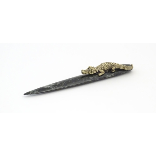 1231 - A 20thC novelty serpentine hardstone paperknife / letter opener / page turner surmounted by a model ... 