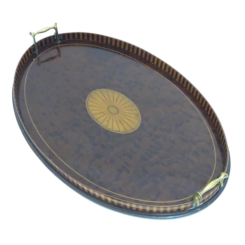 1319 - A 19thC mahogany tray of oval form with satinwood inlay and brass handles. Approx. 15 3/4