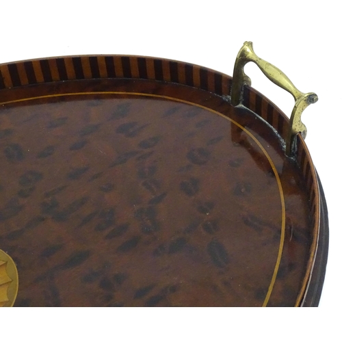 1319 - A 19thC mahogany tray of oval form with satinwood inlay and brass handles. Approx. 15 3/4