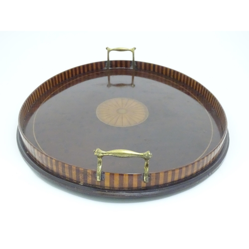 1319 - A 19thC mahogany tray of oval form with satinwood inlay and brass handles. Approx. 15 3/4