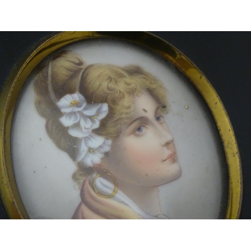 1266 - A 20thC oval watercolour and bodycolour portrait miniature depicting a young lady with flowers in he... 