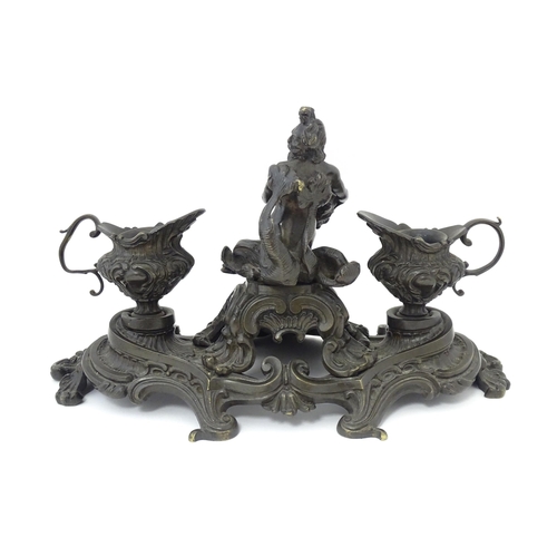 1295 - A cast desk standish in the Renaissance style with central merman flanked by two inkwells, and shell... 