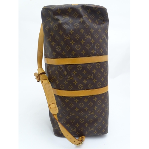 1399 - A Louis Vuitton Keepall 55 bag with shoulder strap and luggage label. Measures 21 3/4 x 12 1/4 x 9 1... 