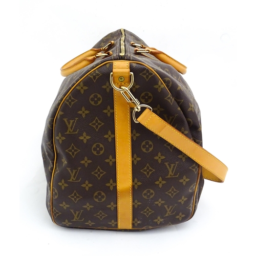 1399 - A Louis Vuitton Keepall 55 bag with shoulder strap and luggage label. Measures 21 3/4 x 12 1/4 x 9 1... 