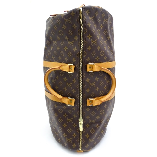 1399 - A Louis Vuitton Keepall 55 bag with shoulder strap and luggage label. Measures 21 3/4 x 12 1/4 x 9 1... 