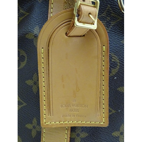 1399 - A Louis Vuitton Keepall 55 bag with shoulder strap and luggage label. Measures 21 3/4 x 12 1/4 x 9 1... 