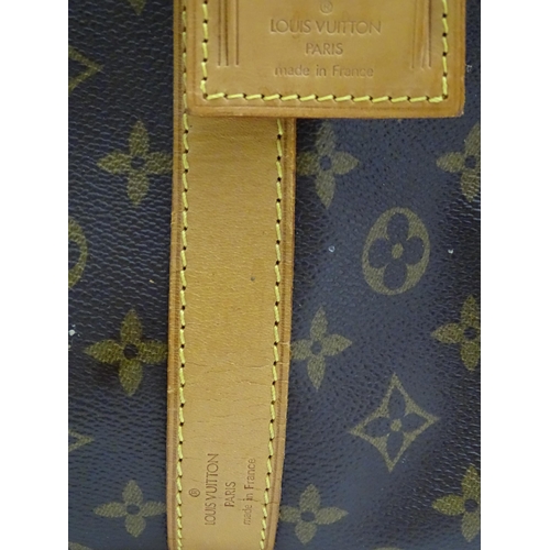 1399 - A Louis Vuitton Keepall 55 bag with shoulder strap and luggage label. Measures 21 3/4 x 12 1/4 x 9 1... 