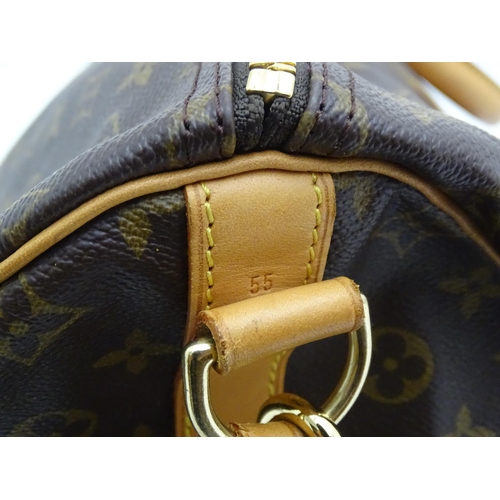 1399 - A Louis Vuitton Keepall 55 bag with shoulder strap and luggage label. Measures 21 3/4 x 12 1/4 x 9 1... 