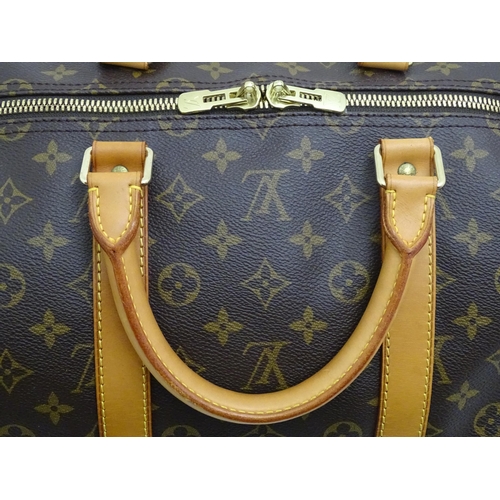 1399 - A Louis Vuitton Keepall 55 bag with shoulder strap and luggage label. Measures 21 3/4 x 12 1/4 x 9 1... 