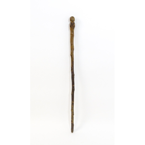 1410 - Stick / Cane : A waking stick with naïve folk art style carved handle formed as the head of the Scot... 